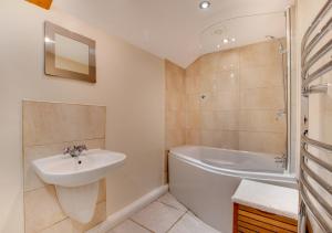 a bathroom with a sink and a tub and a shower at Barn Owl Cottage in Masham