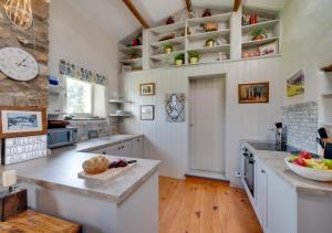 a kitchen with white counters and a clock on the wall at Bizzys Bolthole in Reeth