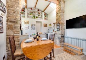 a dining room with a wooden table and a tv at Bizzys Bolthole in Reeth