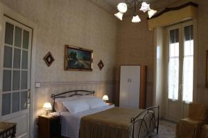 1 dormitorio con cama y lámpara de araña en Palazzo Vitrano - tourist apartment en Catania