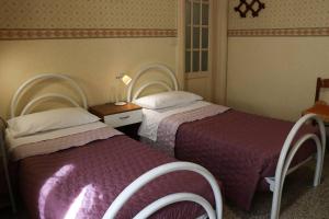 1 dormitorio con 2 camas y mesa con lámpara en Palazzo Vitrano - tourist apartment en Catania