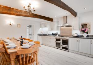 a kitchen with a wooden table and a dining room at Lower Gill Farmhouse in Tosside