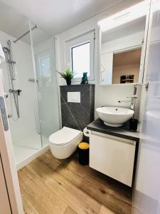 e bagno con servizi igienici, lavandino e doccia. di Iris Holiday Homes - Camping park Soline a Biograd na Moru