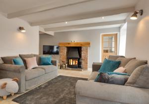 a living room with two couches and a fireplace at Mary End in Hawes