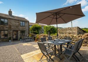 a table with an umbrella in front of a building at Mary End in Hawes