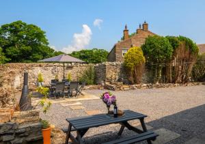 a table with flowers on it in front of a house at Mary End in Hawes