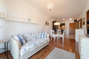 a living room with a couch and a dining room at Nowoczesny Apartament w Helskiej Villi w Helu in Hel +3 photos