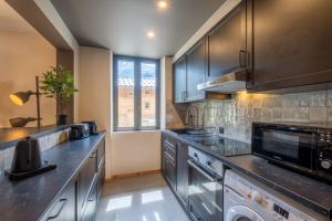 een keuken met roestvrijstalen apparatuur en zwarte kasten bij Newly renovated apartment with Mont Blanc view in Chamonix-Mont-Blanc