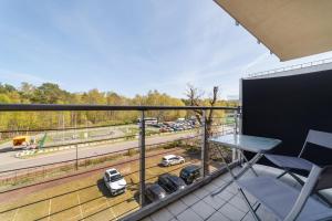 un balcón con una mesa y algunos coches en una pista en Nowoczesny Apartament w Helskiej Villi w Helu en Hel