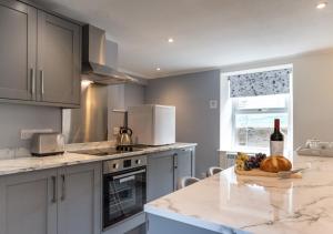 a kitchen with a table with a bottle of wine at Ghyllfoot Apartment in Gunnerside