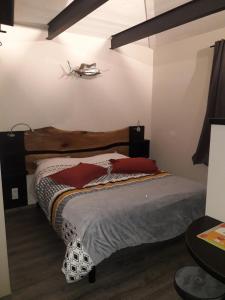 1 dormitorio con 1 cama con cabecero de madera en EN PASSENT PAR LA LORRAINE 