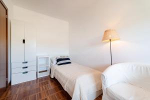 a white bedroom with two beds and a lamp at Nowoczesny Apartament w Helskiej Villi w Helu in Hel