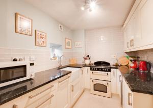 a kitchen with white appliances and black counter tops at Church View - Askrigg in Askrigg