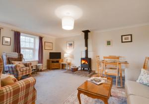 a living room with a couch and a stove at Church View - Askrigg in Askrigg