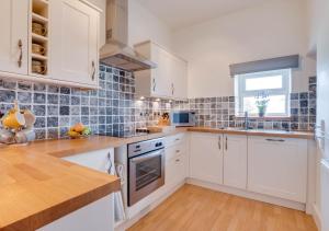 a white kitchen with white cabinets and a window at Upper Cherry Bank in Bainbridge