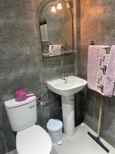 a bathroom with a white toilet and a sink at Residence el khannchi in Laayoune