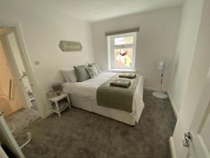 a small bedroom with a bed and a window at Rhondda Tunnel Cottage by StayStaycations in Treorky