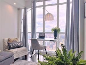 a living room with a desk in front of a large window at TVHR - Luxury Condos in Heart of Downtown in Toronto