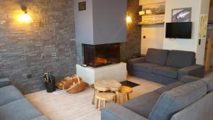 a living room with a couch and a fireplace at Chalets Residence Snoweden in Montchavin