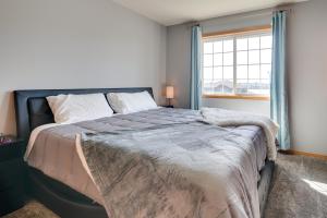 a bedroom with a large bed with a window at Moses Lake Vacation Rental with Hot Tub and Game Room in Moses Lake