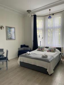 a bedroom with a bed and a desk and windows at Sopot Monte Cassino Wiktoria Apt in Sopot