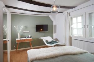 a bedroom with a bed and a chair and a tv at Ferienhaus Apple Tree in Treis-Karden