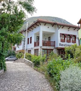 a white house with a road in front of it at Boutique Hotel Old Town Mostar in Mostar