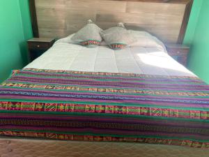 聖佩德羅·德·阿塔卡馬的住宿－Casas Particulares, Tipo Cabañas.，床上有色彩缤纷的毯子和枕头