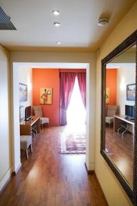 Una sala de estar con un espejo y un escritorio y una ventana. en STELLA CHARMING & LUXURY ROOMS, en Conversano