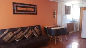 sala de estar con sofá negro y mesa en Casas Particulares, Tipo Cabañas. en San Pedro de Atacama