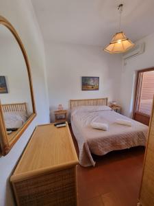 1 dormitorio con cama, mesa y espejo en Hotel Portofina, en Santa Marinella