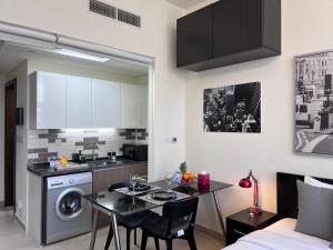 eine Küche und ein Wohnzimmer mit einem Tisch im Zimmer in der Unterkunft Super Studio in Dubai in Dubai