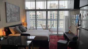 1 dormitorio con cama y ventana grande en Super Studio in Dubai en Dubái