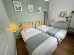 two beds in a small room with at L’Accostage in Dieppe