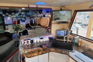 eine Küche in einem Wohnwagen mit einem Waschbecken und einem Laptop in der Unterkunft COZY CONDO OCEAN 3xDECK YACHT in Brooklyn