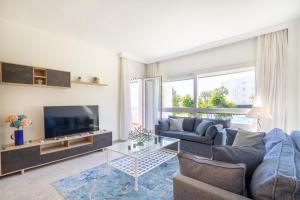 un soggiorno con divano e TV di MARBELLA BANUS SUITES - Banus Playa Rocio Beachfront Complex a Marbella
