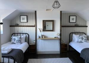 a bedroom with two beds and a mirror on the wall at 1 Browcote Cottage in Ravenscar