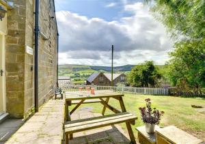 a wooden picnic table in a yard next to a building at 2 Bransdale Cottage in Glaisdale