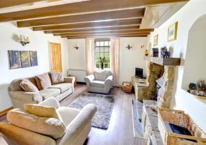 un salon avec des canapés et une cheminée dans l'établissement 2 Bransdale Cottage, à Glaisdale