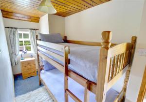a bedroom with a bunk bed with a wooden ceiling at 2 Bransdale Cottage in Glaisdale