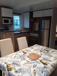 a kitchen with a table and a refrigerator at MOBIL-HOME 6-8 pers, Domaine de Kerlann 4* in Pont-Aven