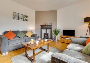 uma sala de estar com um sofá e uma mesa em 2 Moorcock Cottages em Cotterdale