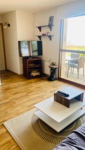 uma sala de estar com uma televisão e uma mesa em Font-Romeu : T2 avec grande terrasse et garage em Font Romeu Odeillo Via