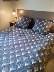 łóżko z niebiesko-białą kołdrą w pokoju w obiekcie MOBIL-HOME 6-8 pers, Domaine de Kerlann 4* w mieście Pont-Aven