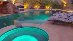 a swimming pool with a green swimming pool at Luxury Villa, with bonus pool house, Private Pool, Hot tub, rock water fall and slide, putting green, basketball, shuffle board, play gym, privately gated on circular driveway. in Las Vegas