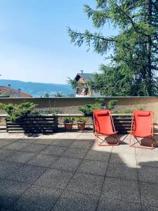 Deux chaises orange sont installées sur une terrasse. dans l'établissement Font-Romeu : T2 avec grande terrasse et garage, à Font-Romeu-Odeillo-Via