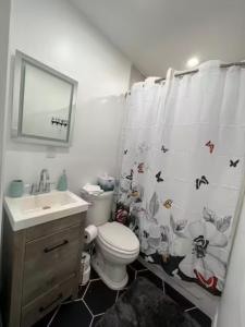 a bathroom with a toilet and a shower curtain at 1st floor apt 3 bed/ 2 bath in downtown orlando in Orlando
