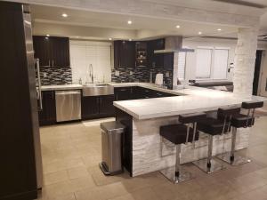 a large kitchen with a large island with bar stools at Luxury Villa, with bonus pool house, Private Pool, Hot tub, rock water fall and slide, putting green, basketball, shuffle board, play gym, privately gated on circular driveway. in Las Vegas