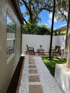 un patio trasero con una pasarela de piedra junto a una casa en 1st floor apt 3 bed/ 2 bath in downtown orlando en Orlando