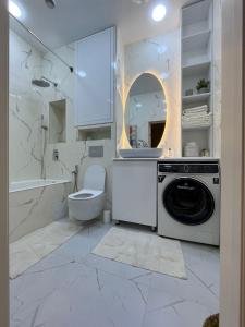 a bathroom with a washing machine and a toilet at Almira in Dushanbe